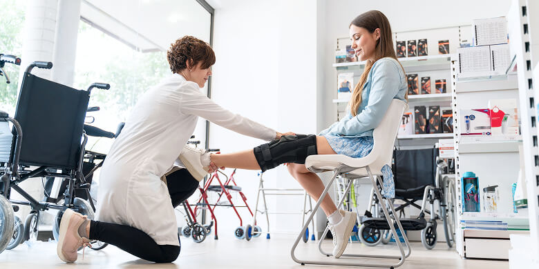 Fachperson Passt Knieorthese Bei Patientin An