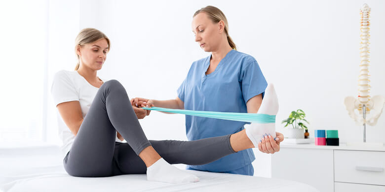 Physiotherapeutin Führt Beinübung Mit Widerstandsband Durch
